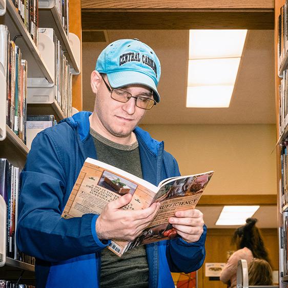 Student reading book in library 